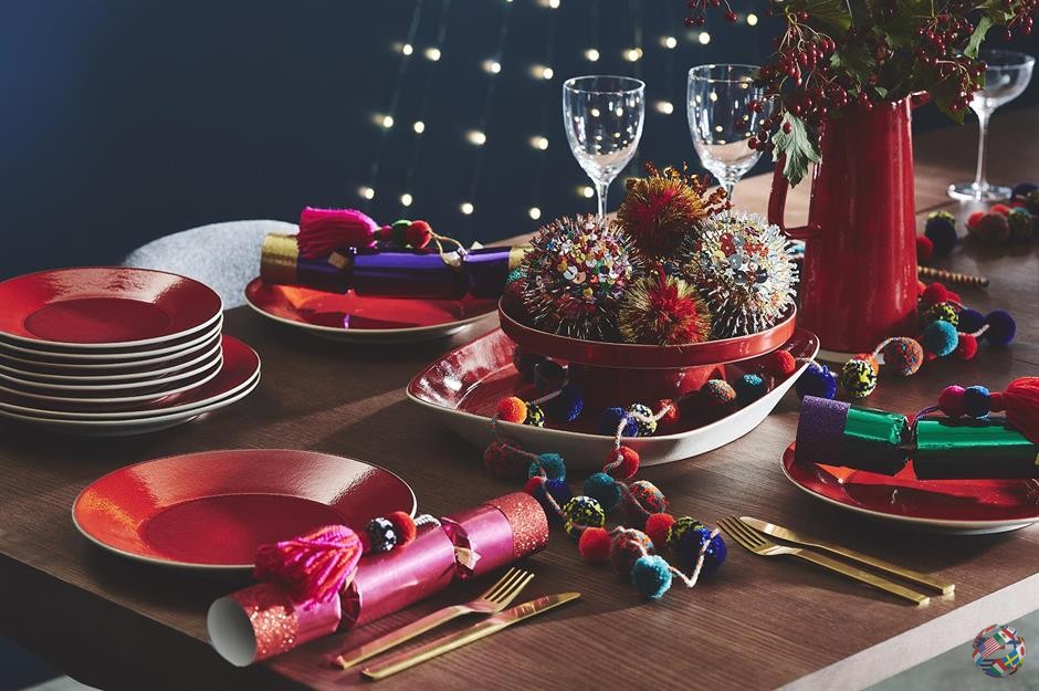 Добавьте игривости к рождественскому столу, который упакован в современный пунш с помпонами ярких цветов. Сложите блестящие шарики в декоративную посуду и используйте гирлянду с помпонами, чтобы непринужденно обернуть их вокруг.