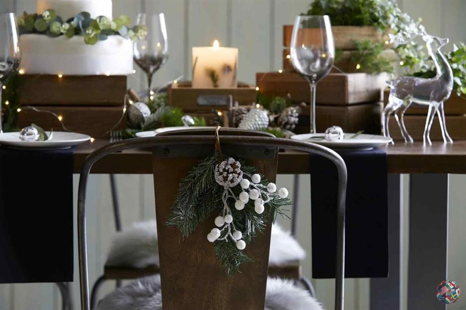 Возьмите элементы дизайна рождественского стола и сделайте из них украшение, которое можно повесить на спинку каждого стула. Нацельтесь на небольшую группу деталей, таких как еловые шишки и обрезки, декоративные бусинки или ягоды, и соедините их вместе, чтобы они могли зацепиться за спинку стула.
